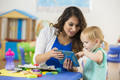 Photo of teacher and small child with iPad